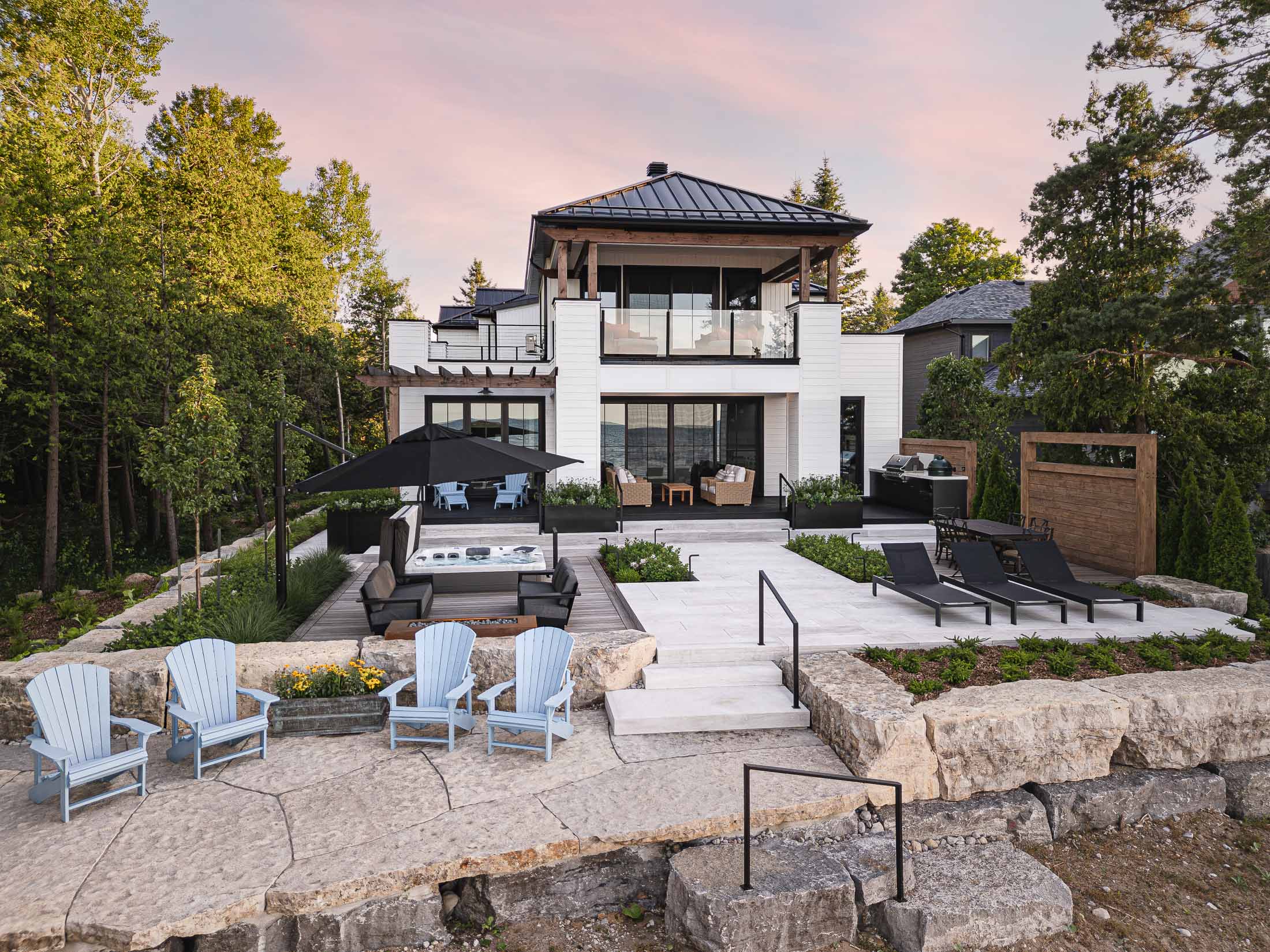 Modern outdoor living design with hot tub and fire feature by Collingwood custom home builder