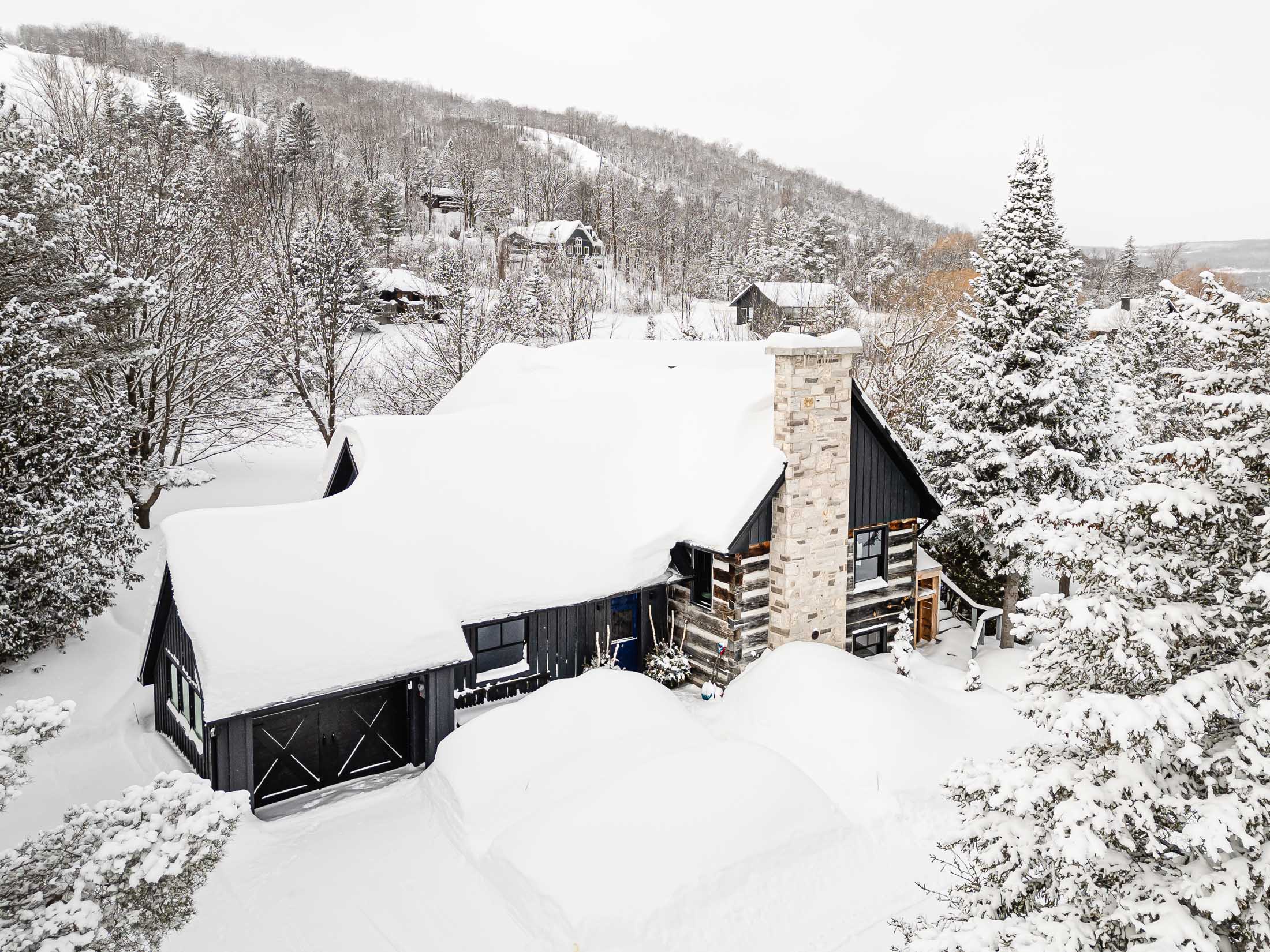 Renovated chalet exterior with original log cabin and modern addition in Blue Mountain