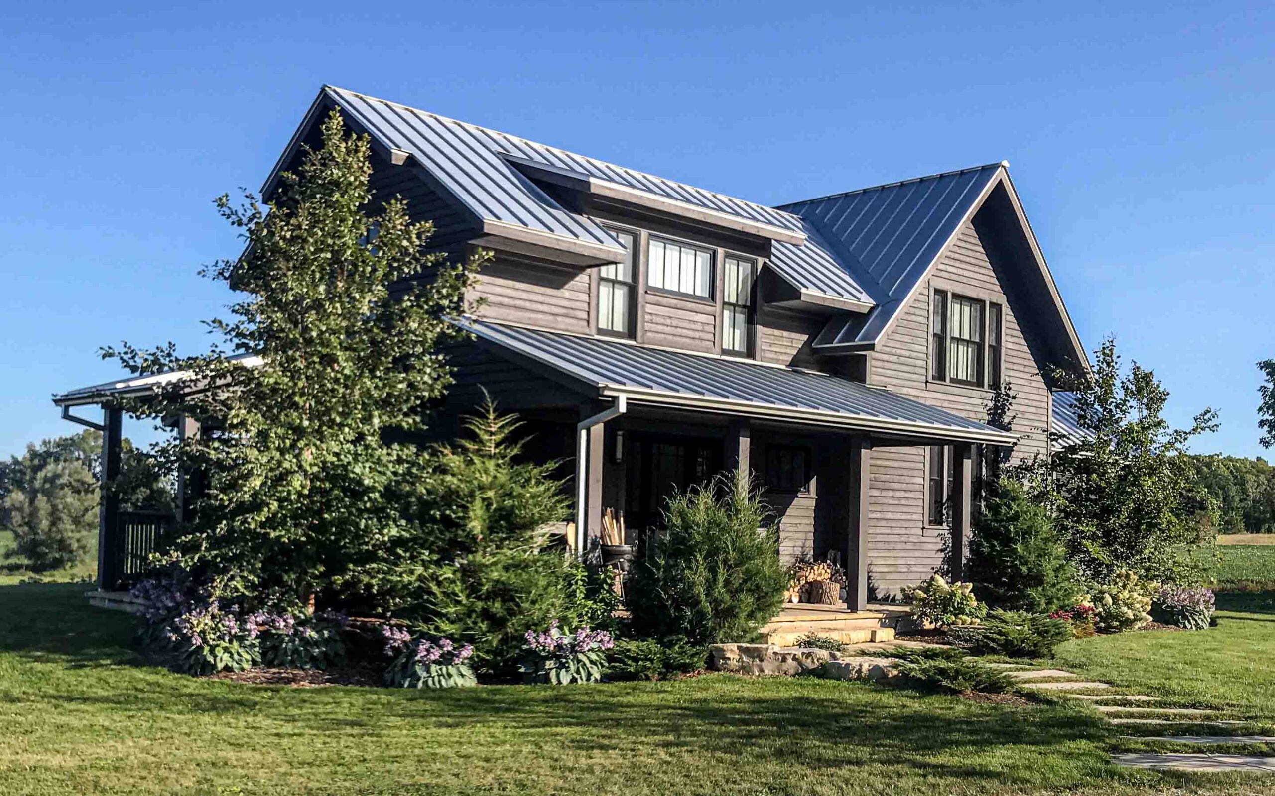 The exterior of a contemporary farmhouse up on a hill. Built by Blake Farrow Project Management, designed by IBI Group Architects