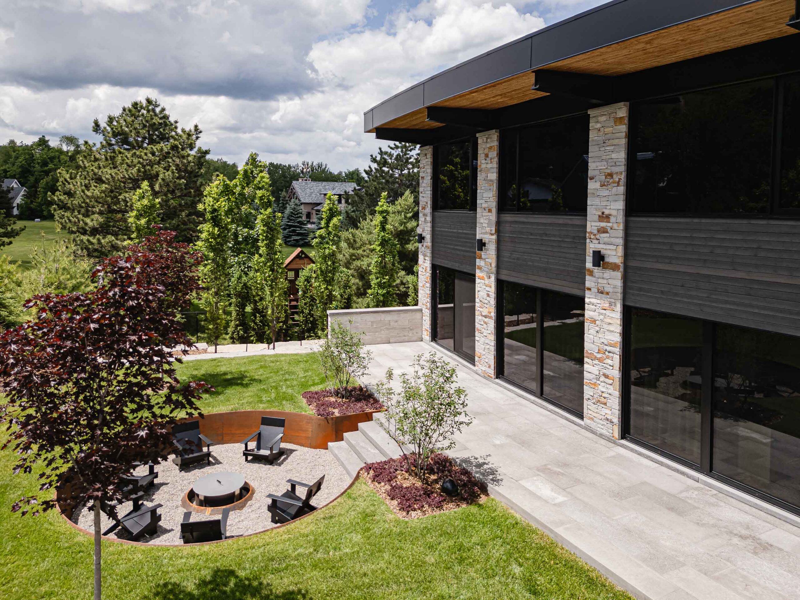 Aerial view of the recessed fire pit with custom steel edging at a custom chalet built by a Collingwood custom home builder