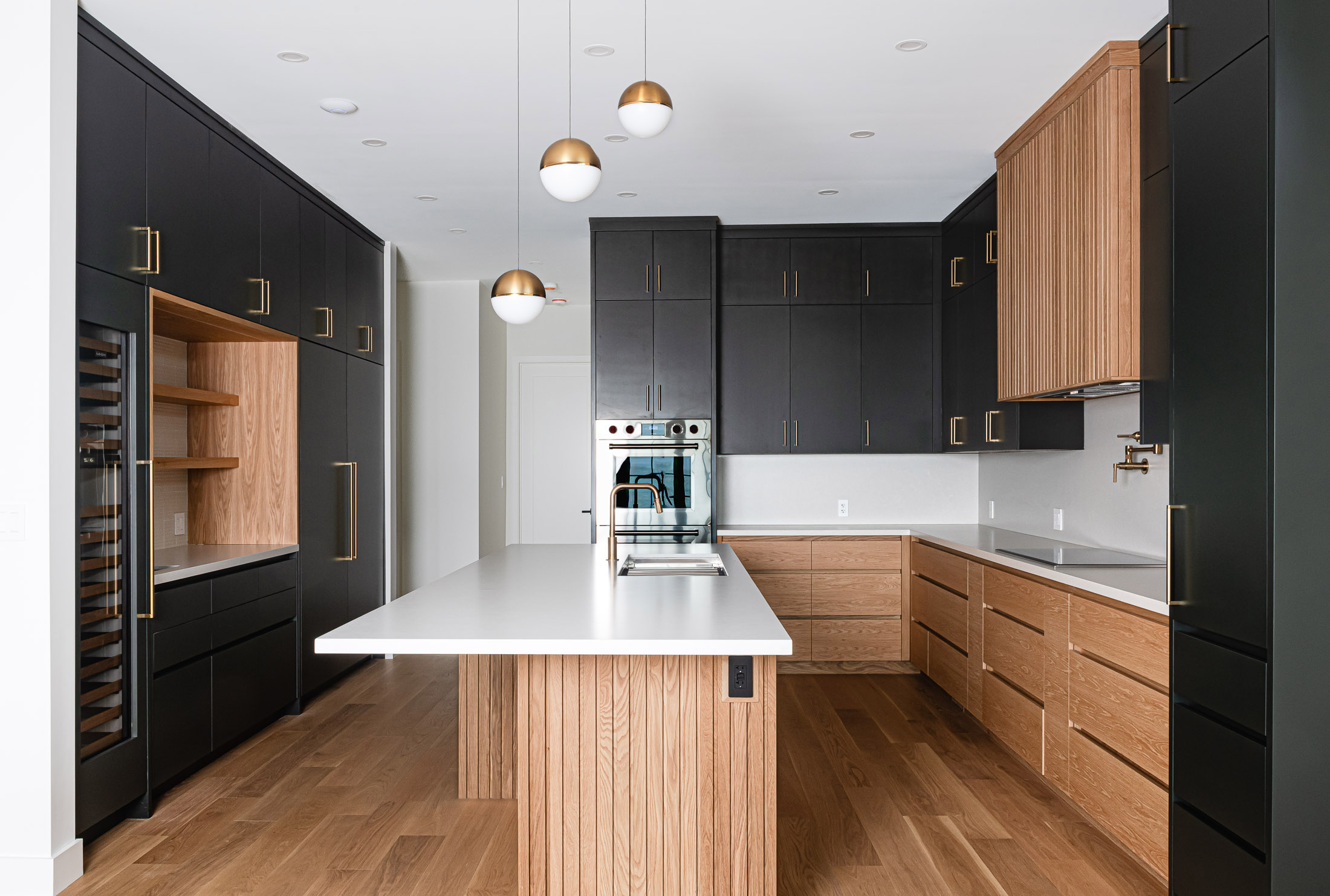 Contemporary kitchen with ribbed wood details and custom cabinetry by Collingwood custom home builder