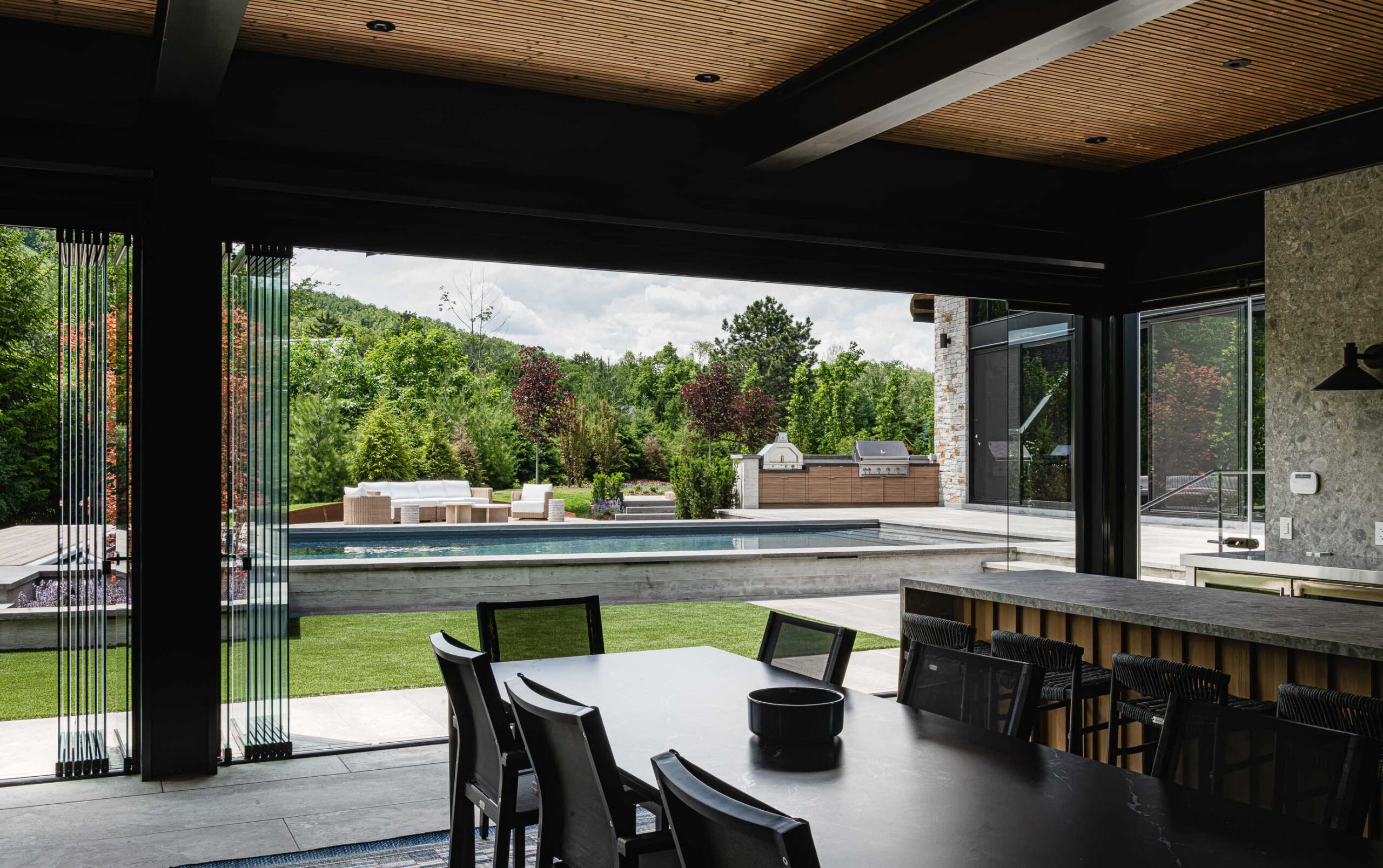 Modern pool house in Blue Mountain featuring open-concept living, retractable glass walls, and seamless indoor-outdoor living