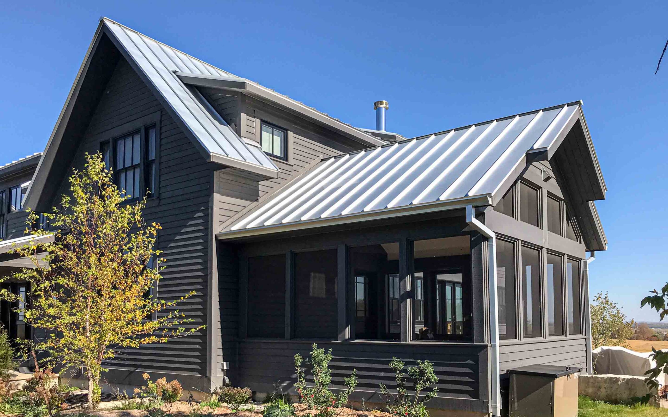 The exterior of a contemporary farmhouse up on a hill. Built by Blake Farrow Project Management, designed by IBI Group Architects