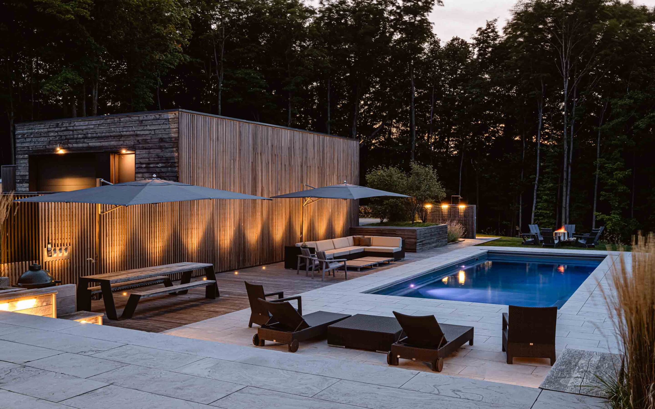 a modern pool and lounge area lit up at night