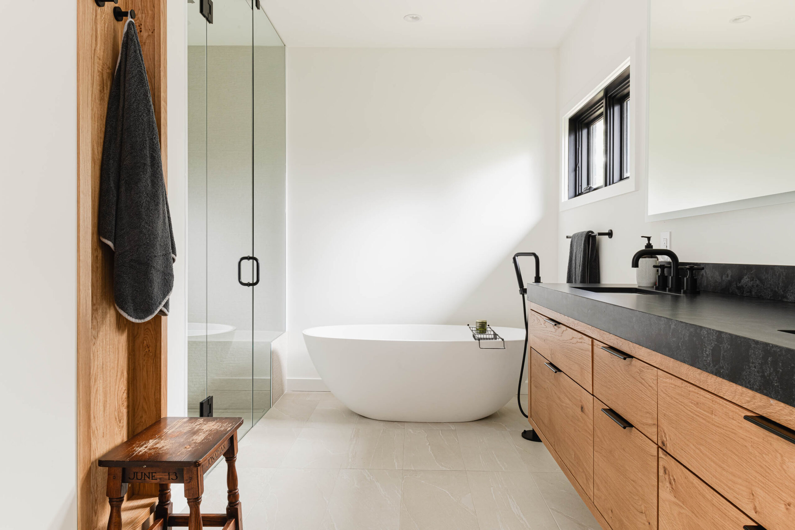 Modern rustic bathroom with egg bathtub, glass shower and custom vanity