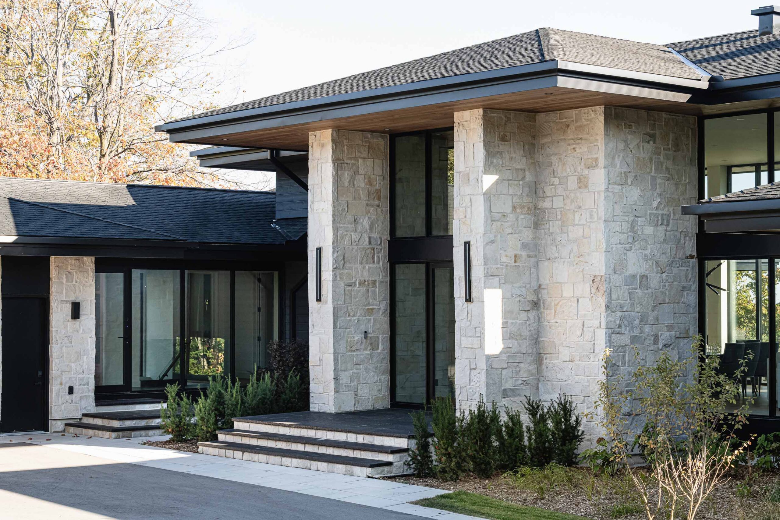 Contemporary country home exterior with stone detailing and extensive glass