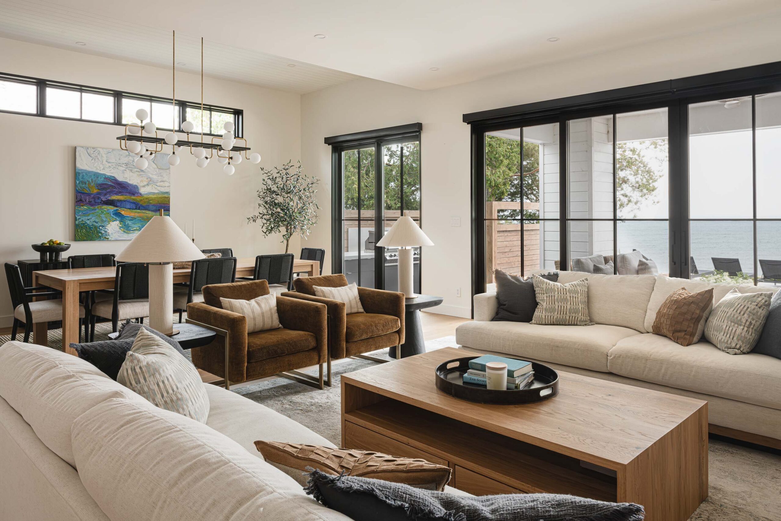 Contemporary beach house living room with expansive black framed doors opening to an outdoor living space