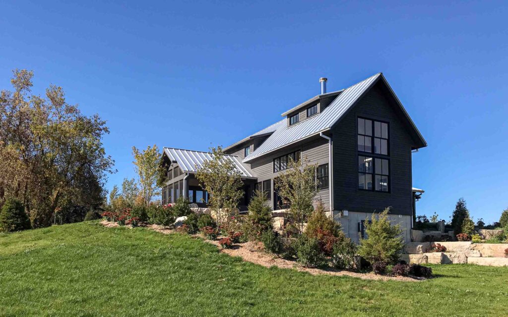 The exterior of a contemporary farmhouse up on a hill. Built by Blake Farrow Project Management, designed by IBI Group Architects