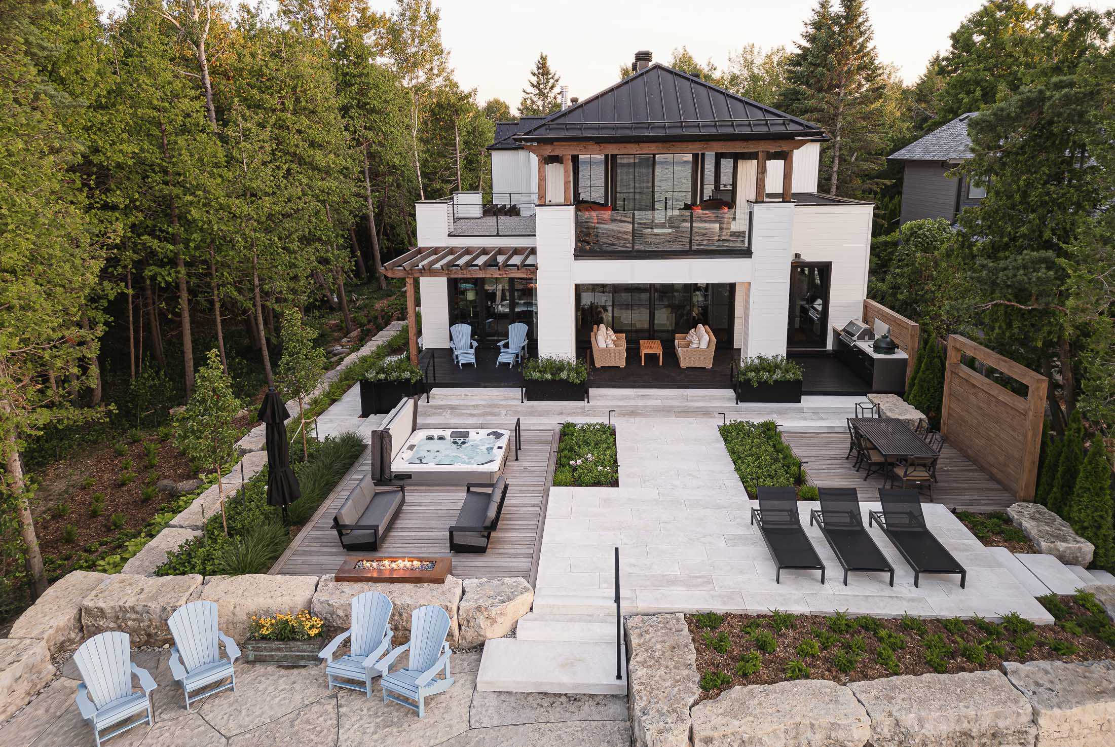 Contemporary waterfront home with hot tub and multiple lounge spaces built by a Collingwood custom home builder