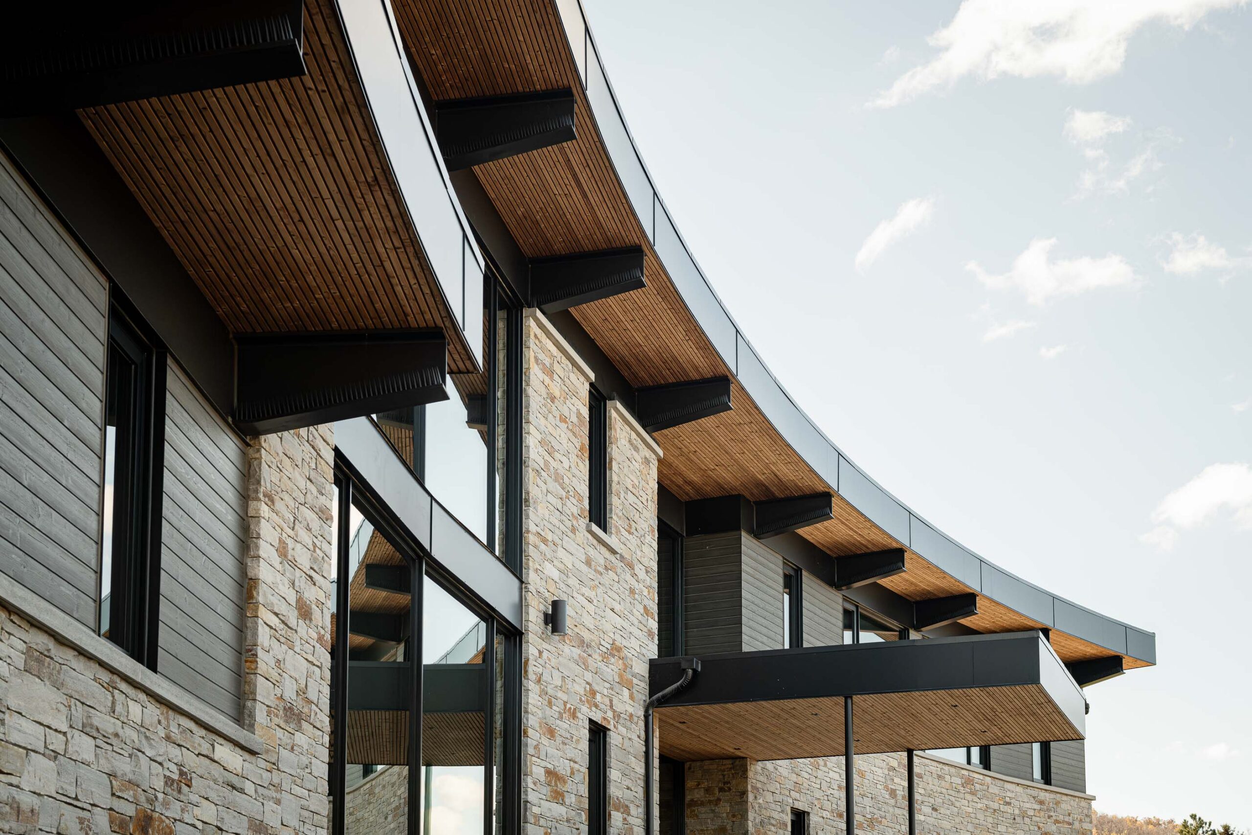 Contemporary chalet exterior with distinctive curved architecture