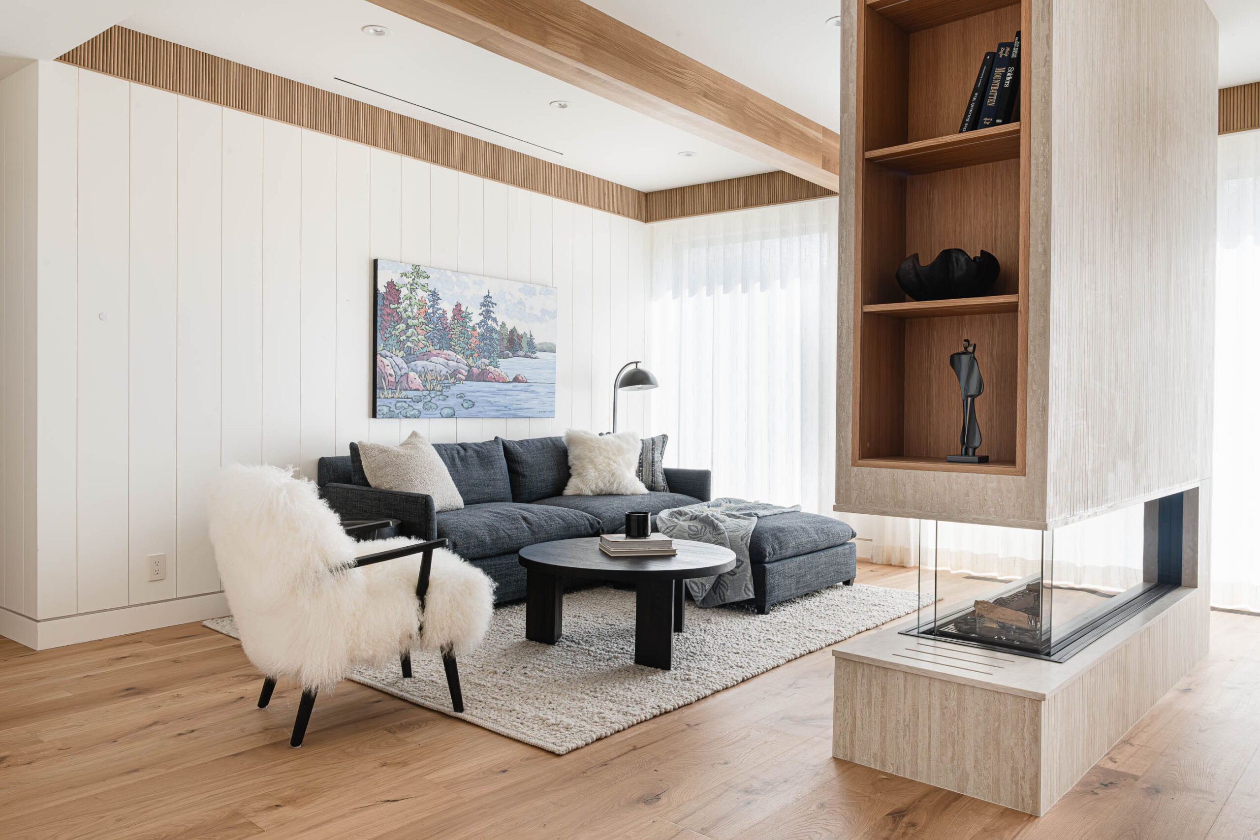 Contemporary Blue Mountain chalet bedroom sitting area with floor-to-ceiling windows, modern furniture and a tile and glass double-sided fireplace