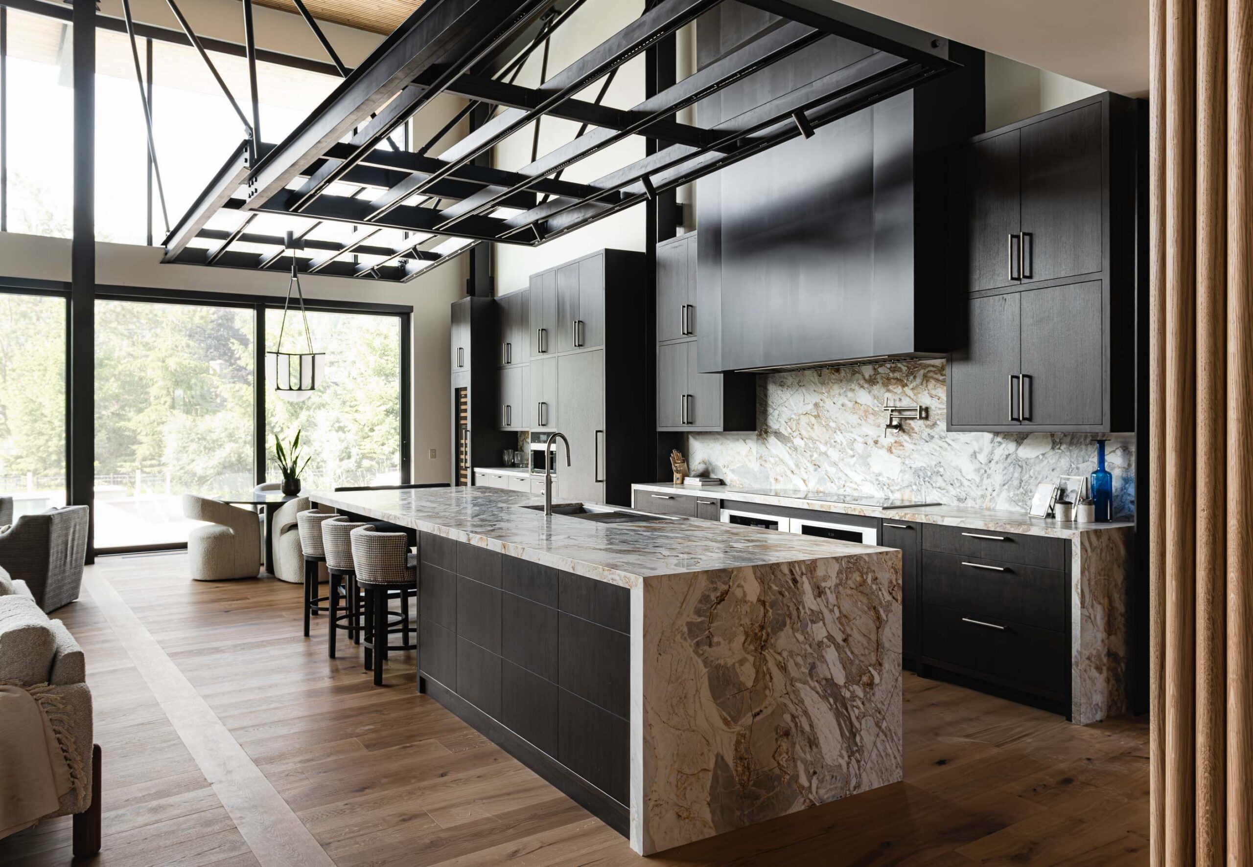 Contemporary kitchen in a luxury Blue Mountain chalet with waterfall countertop and industrial ceiling elements