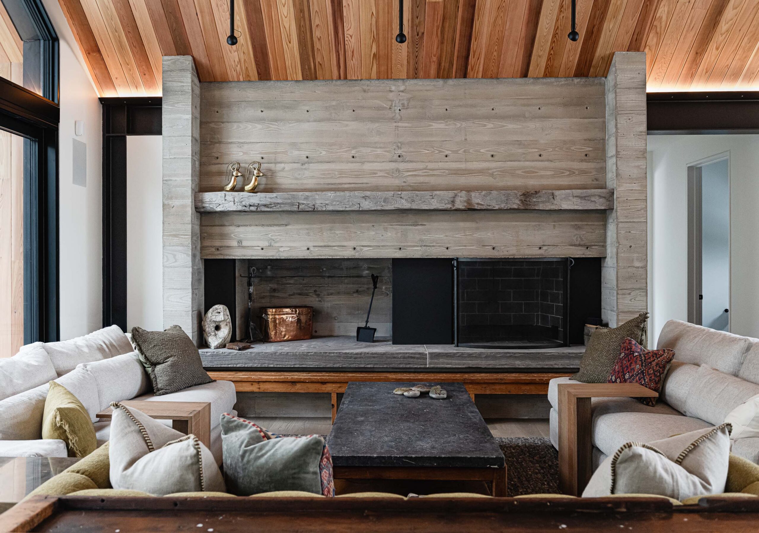 Board formed concrete fireplace with reclaimed timber mantle in a modern Blue Mountain chalet build