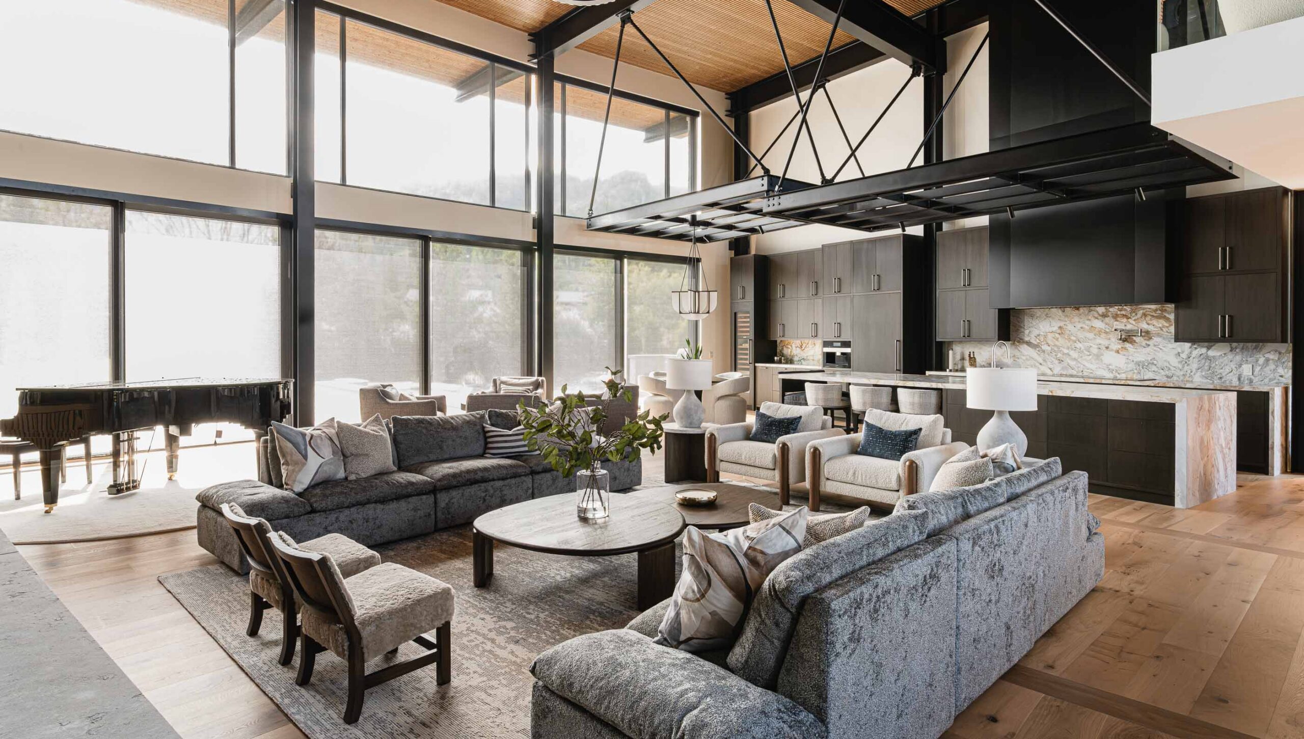 Two-storey great room in a luxury, contemporary chalet with oversized patio doors, industrial metal detailing and contemporary finishes