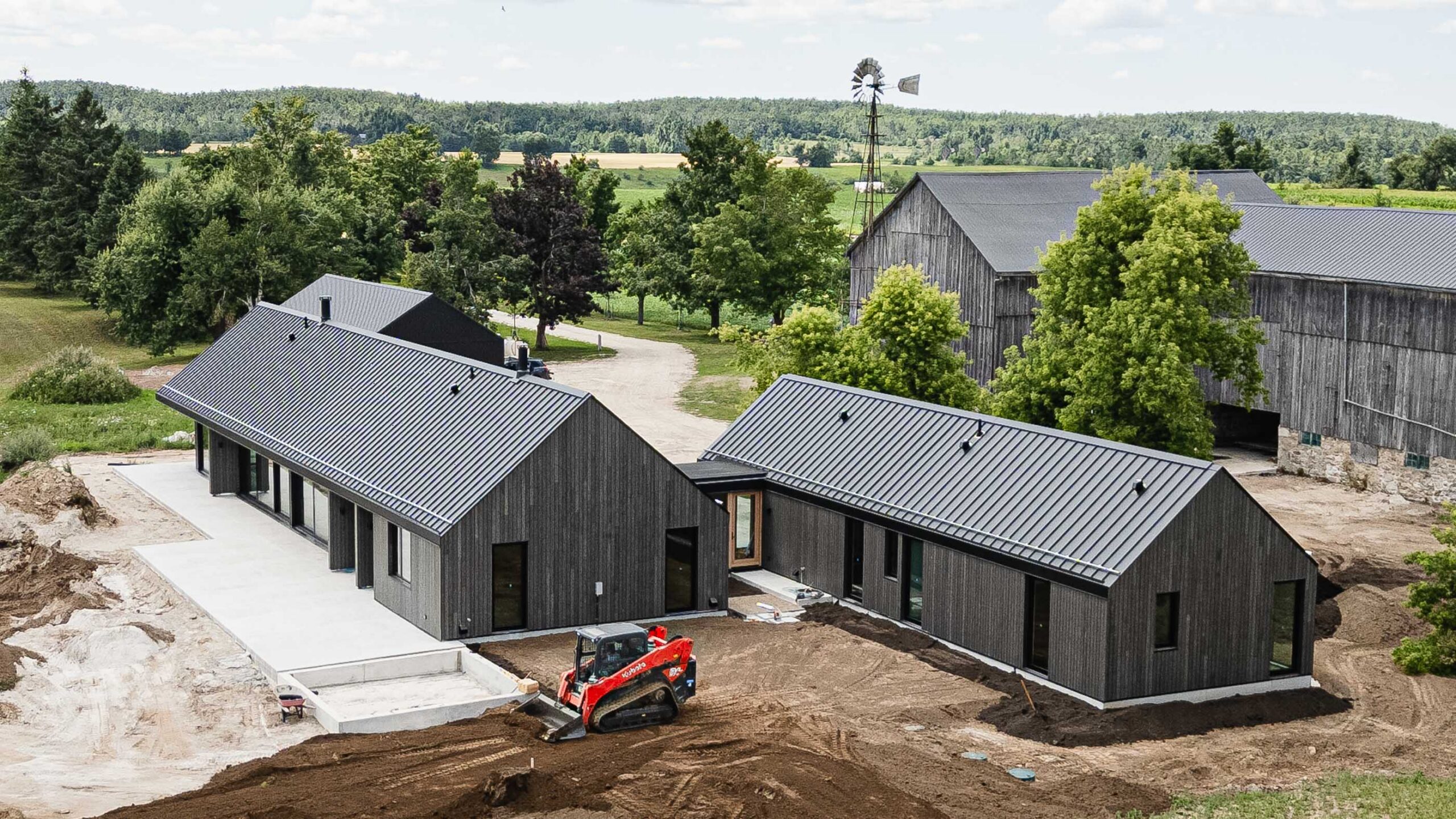 Rear elevation of a modern barn farmhouse being built by an Ontario custom home builder, with landscaping in progress