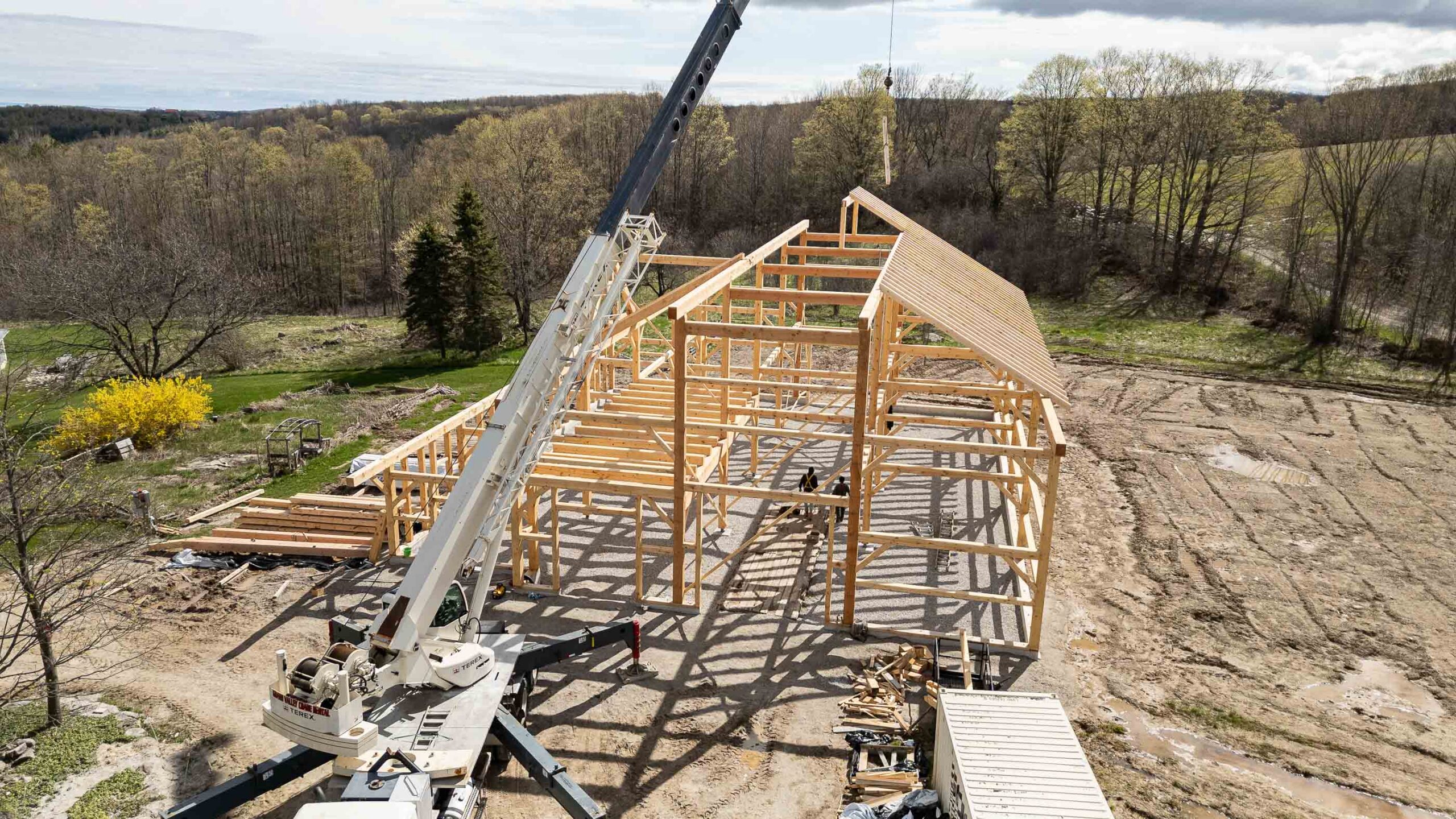 aerial view of a timber frame barn being built with traditional techniques