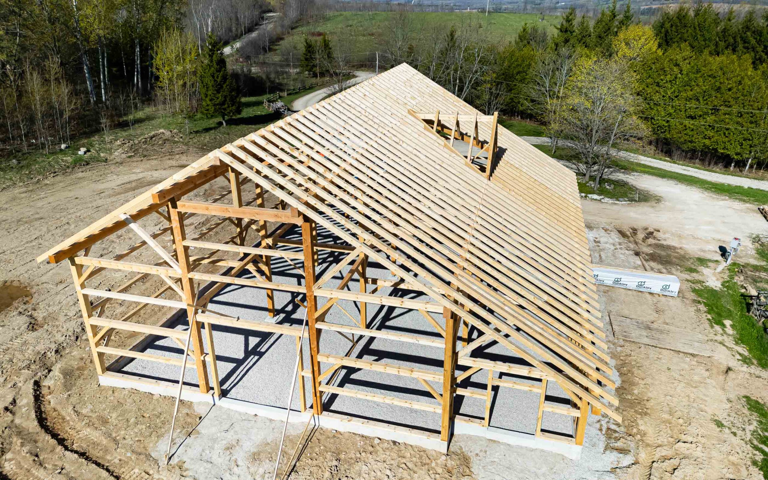 aerial view of a framed modern barn being built with traditional timber framing techniques
