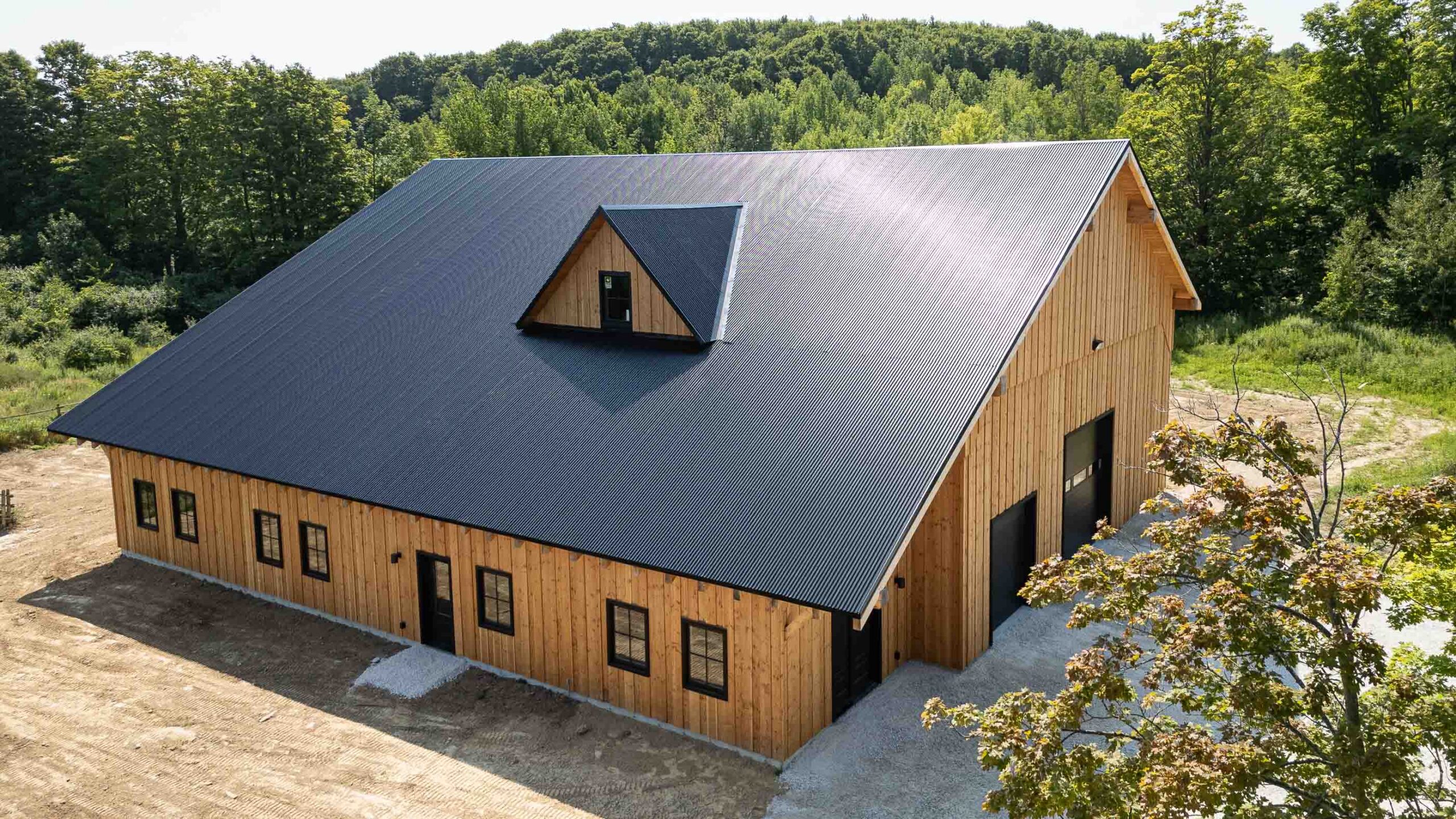 aerial view of a modern timber frame barn with metal roof and contemporary finishes