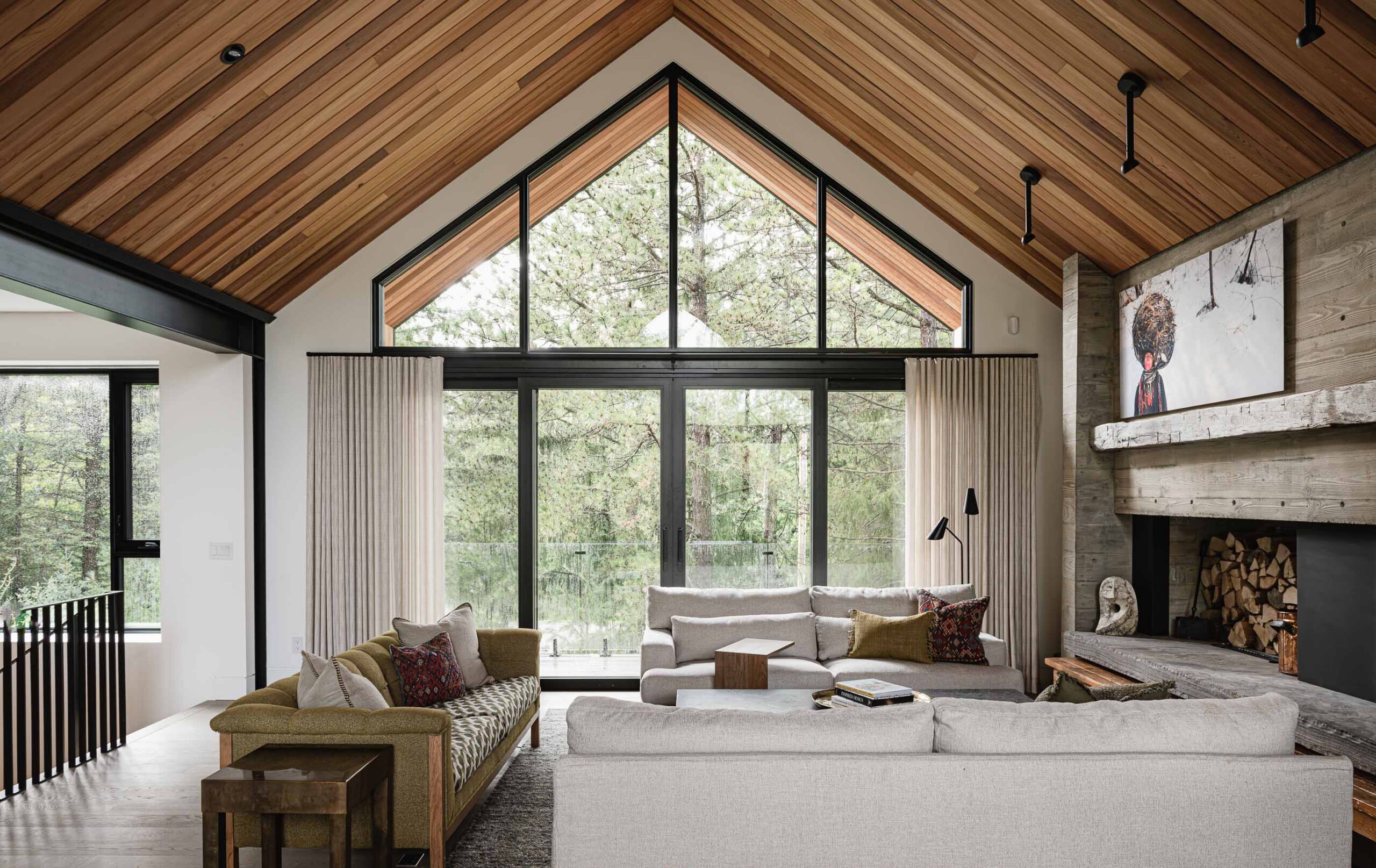 Modern Blue Mountain chalet with vaulted ceiling, extensive glazing, and board-formed concrete fireplace with reclaimed timber mantle