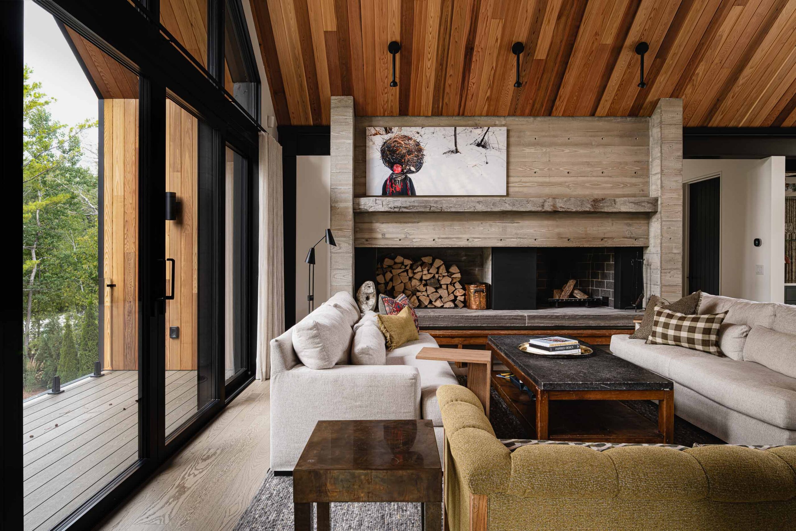 Contemporary Blue Mountain chalet with board-formed concrete fireplace with reclaimed timber mantle, oversized patio doors leading to a covered balcony
