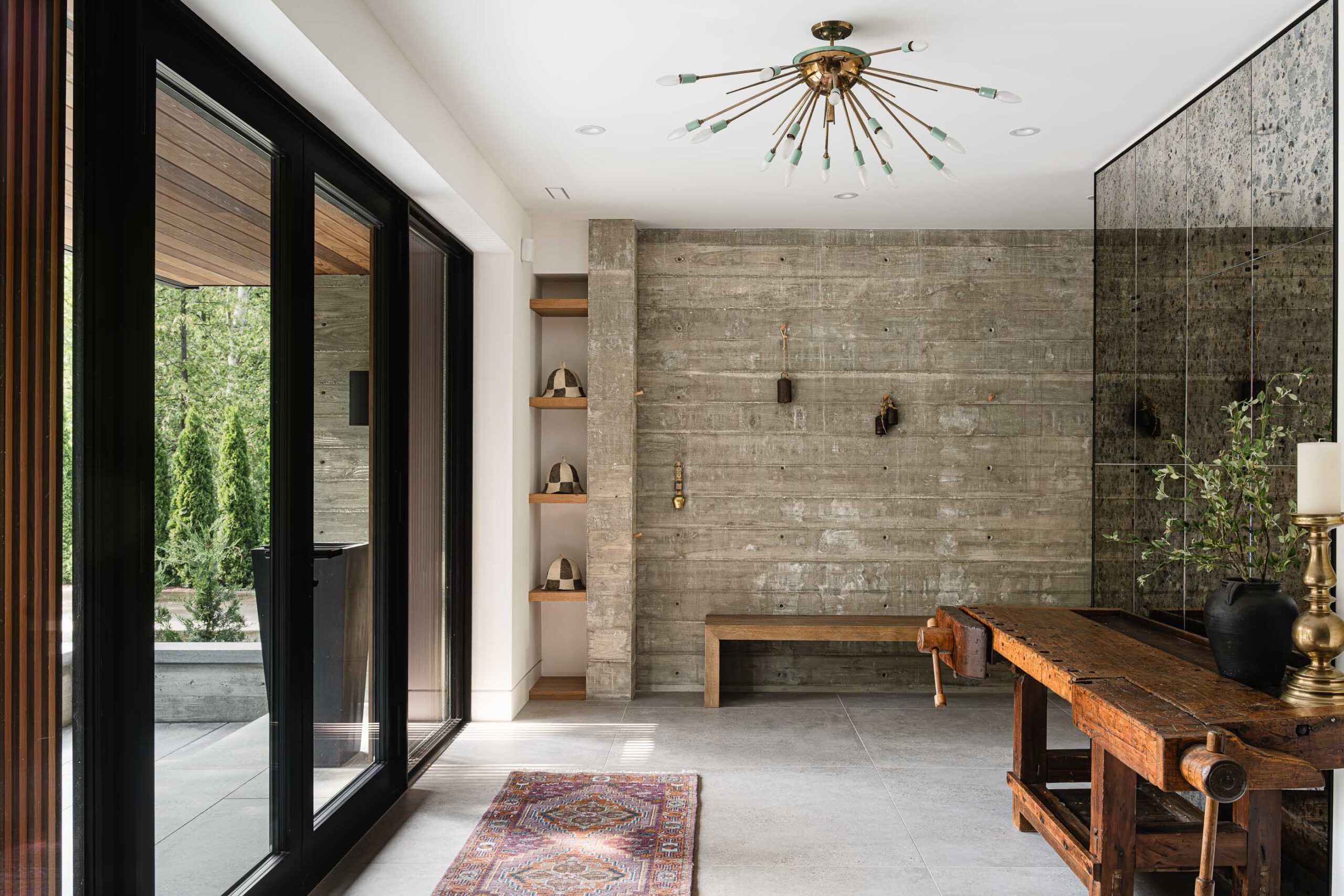 Modern alpine chalet entry with board formed concrete accent wall, antiqued mirrors and polished concrete floors