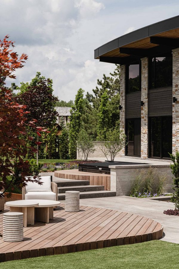 Courtyard detail of a Blue Mountain chalet featuring outdoor seating area and hot tub on elevated wood platforms, extensive landscaping and stone work