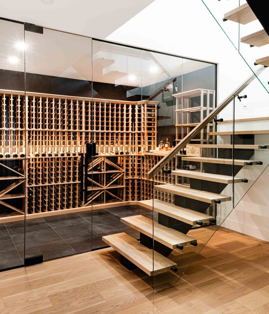 a modern cellar with floor to ceiling glass wall in a custom home