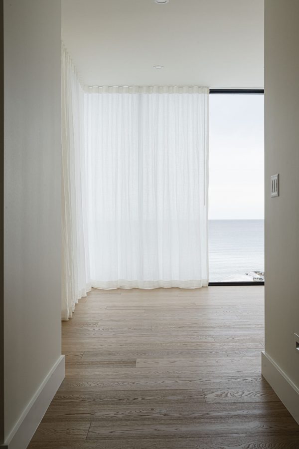 14-Modern-Waterfront elegant sheer curtains across floor to ceiling windows, in a bedroom overlooking the bay