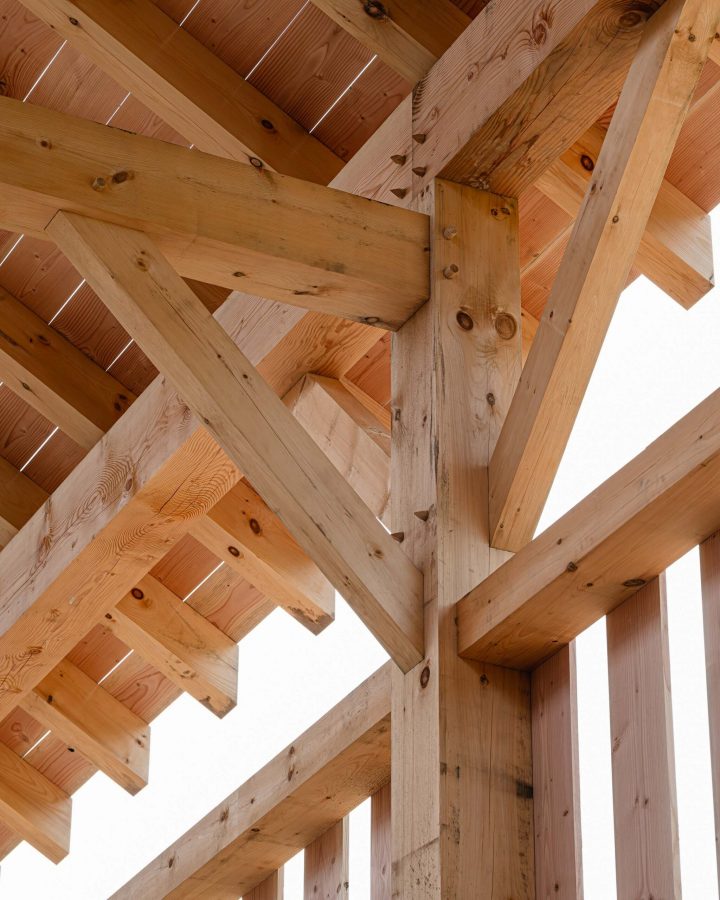 Interior detail of a timber frame structure featuring traditional joinery techniques, pegged mortise and tenons details
