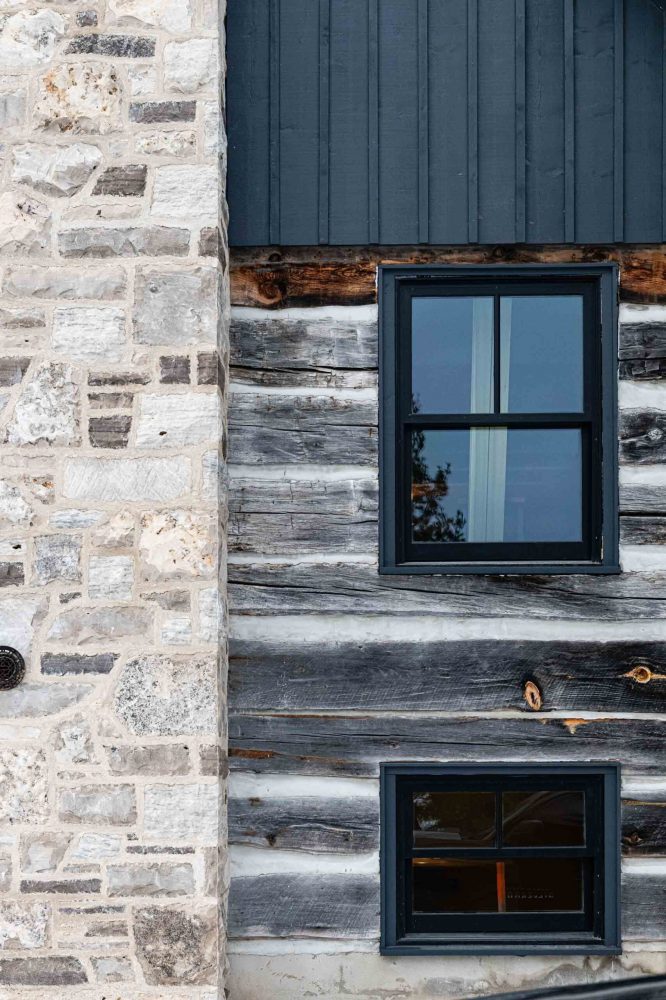 exterior detail of the stone chimney and log exterior of a modernized rustic chalet renovation by Blake Farrow Project