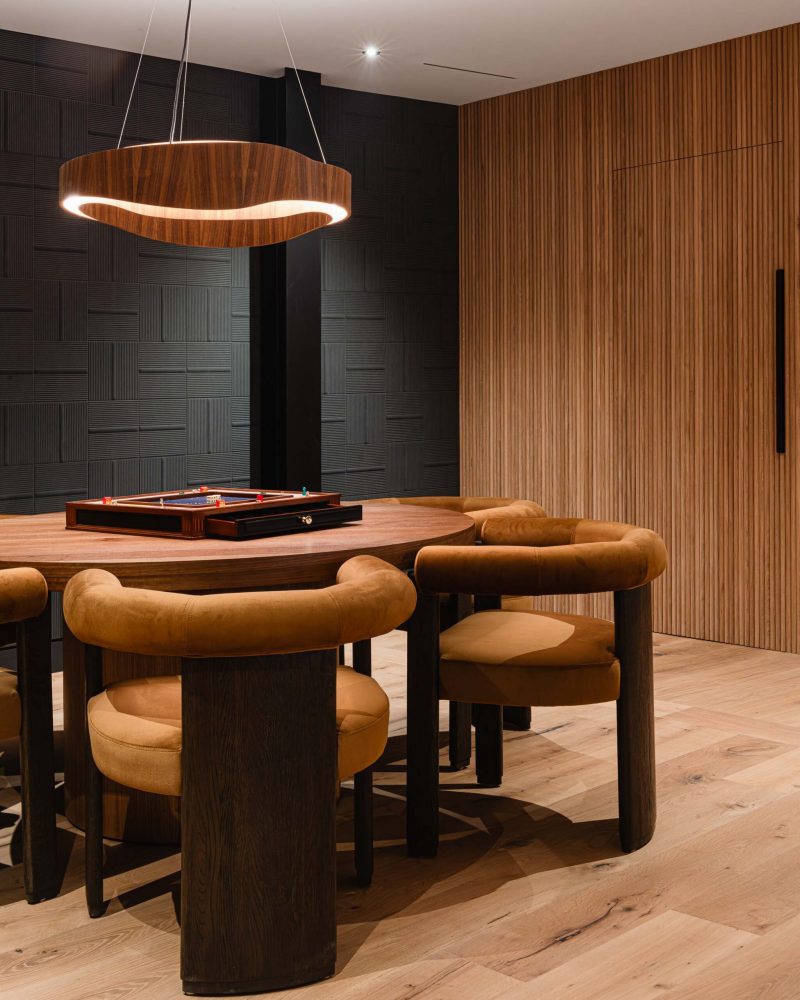 Modern chalet games room detail with textured wallpaper, fluted wood paneling, and contemporary lighting fixtures and furnishings