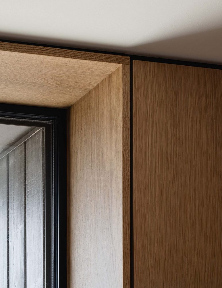 interior detail in a modern barn build showcasing custom oak paneling with integrated reveals