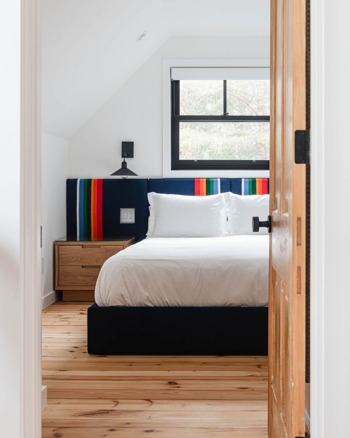 a bedroom in a chalet with hardwood floors and custom felted headboard