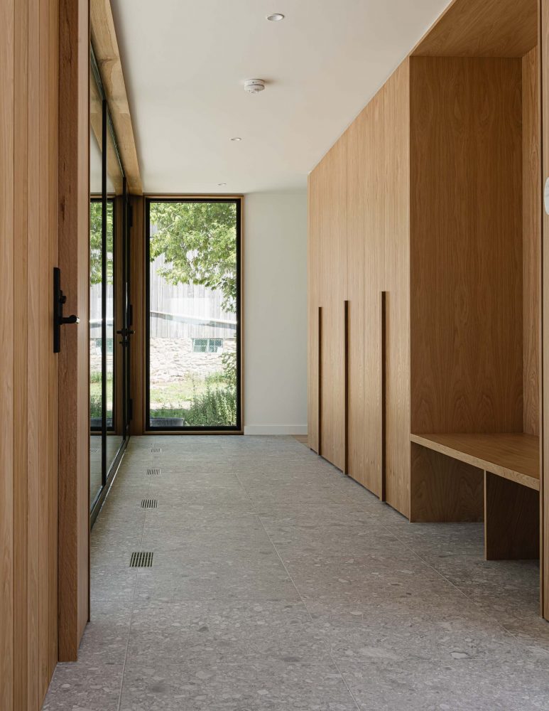 contemporary mudroom with extenseive floor to ceiling windows, custom oak cabinetry and integrated floor vents