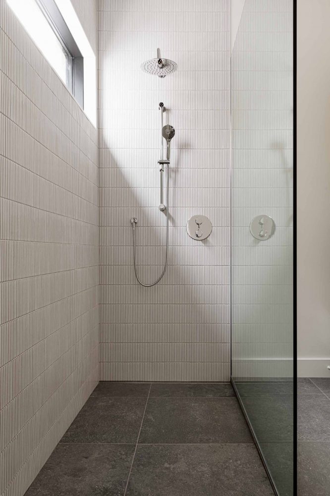 24-Modern-Waterfront shower detail of a contemporary, walk in shower with vertical tiling