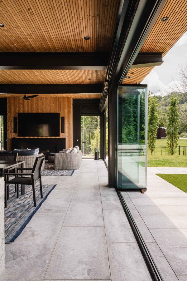 Blue Mountain custom pool house with floor-to-ceiling retractable glass walls opening to the pool terrace