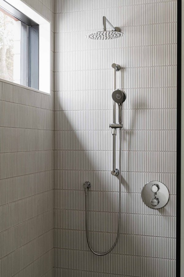 shower detail of a contemporary, walk in shower with vertical tiling