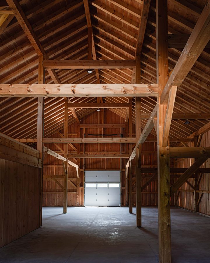 Interior detail of exposed beams in a modern timber frame barn in The Blue Mountains