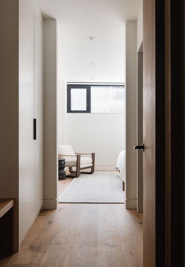 Contemporary chalet bedroom detail with wide-plank wood flooring, baseboard reveal detail, and custom millwork