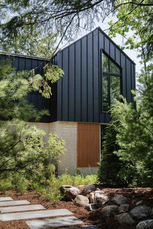 Nordic-inspired Blue Mountain chalet with board formed concrete walls, black metal siding and wood detailing