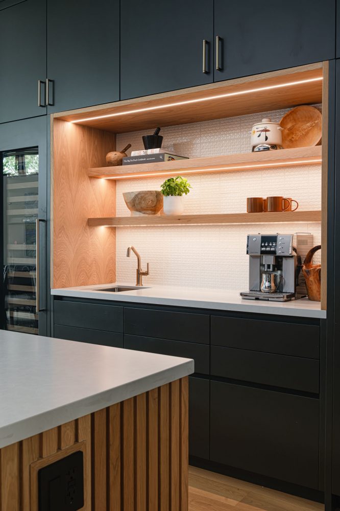 Custom beverage station in a modern beach house kitchen with charcoal custom cabinets, wood detailing, and clean lines