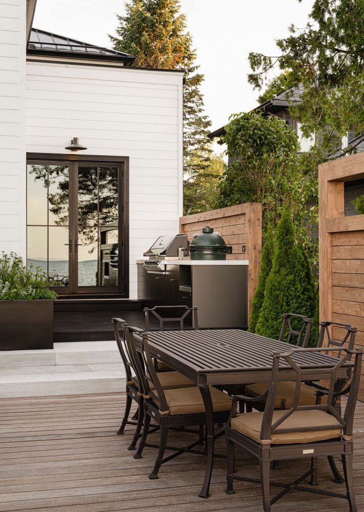 Modern outdoor living design with outdoor kitchen and dining area by Collingwood custom home builder