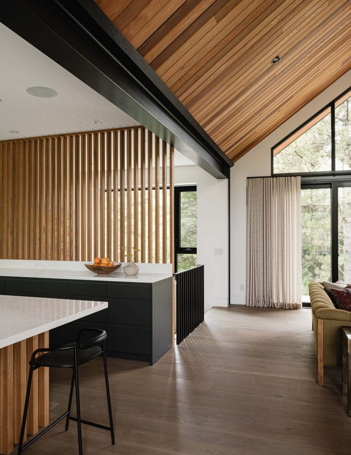 Architectural detail of a modern alpine chalet featuring slated wood divider wall, exposed steel accents and contemporary finishes